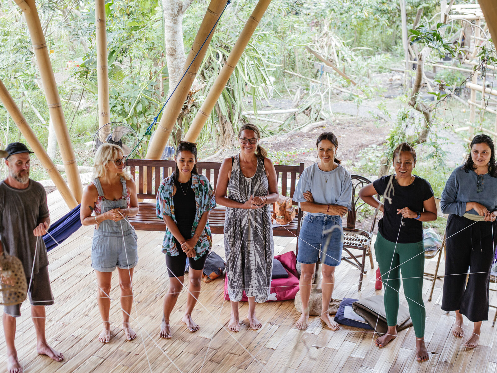 A group standing together inside the bamboo shala.