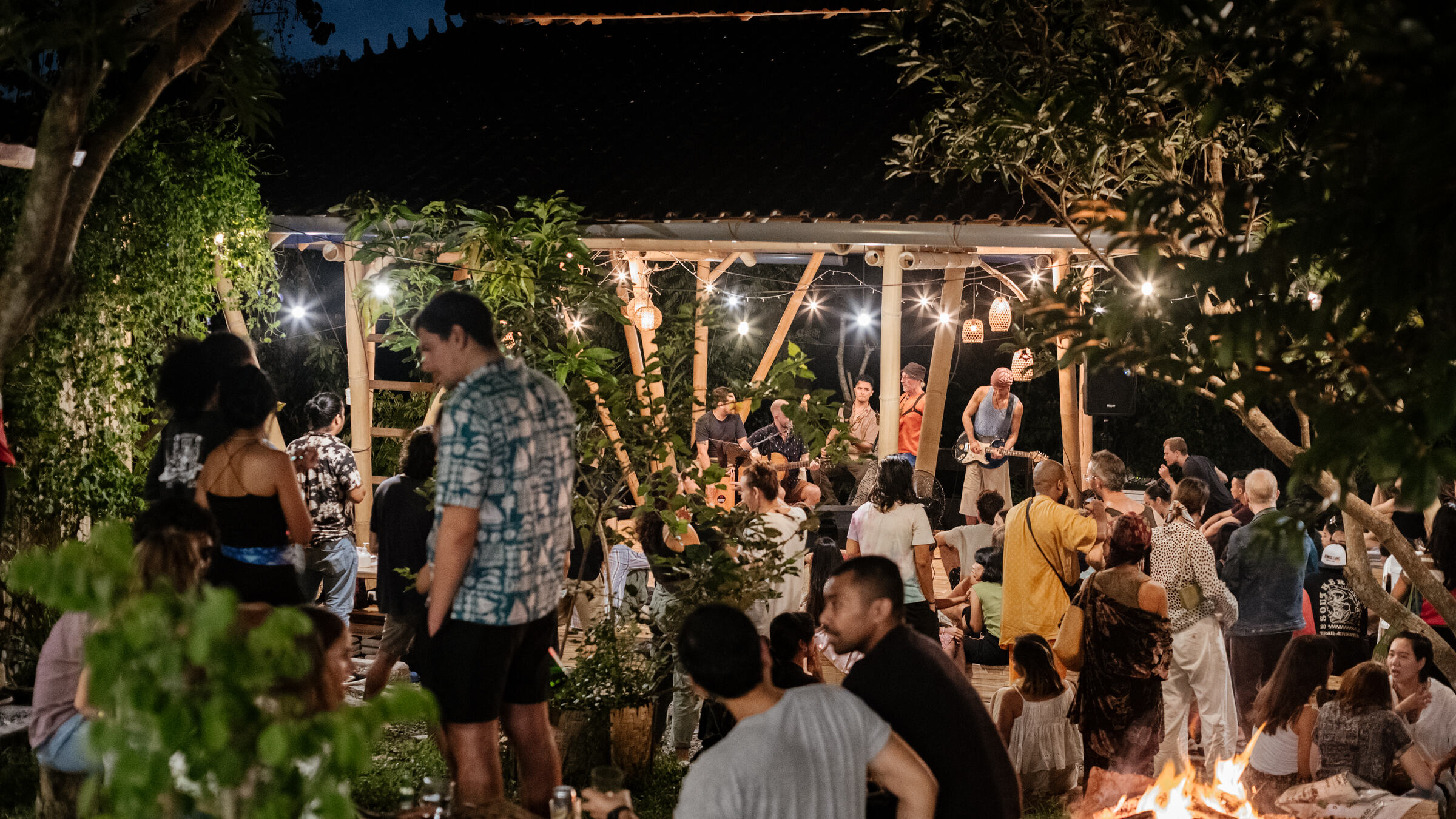 An evening gathering under string lights in the garden.
